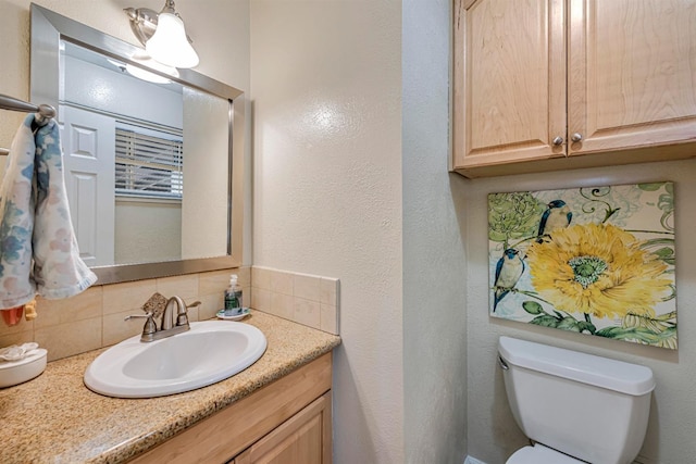 half bath featuring vanity, backsplash, and toilet