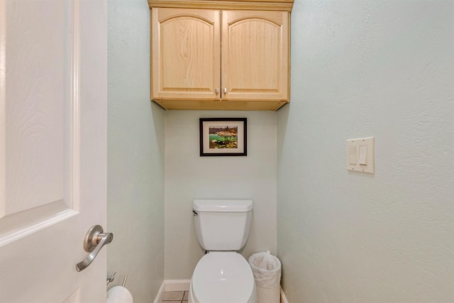 half bath with toilet and baseboards