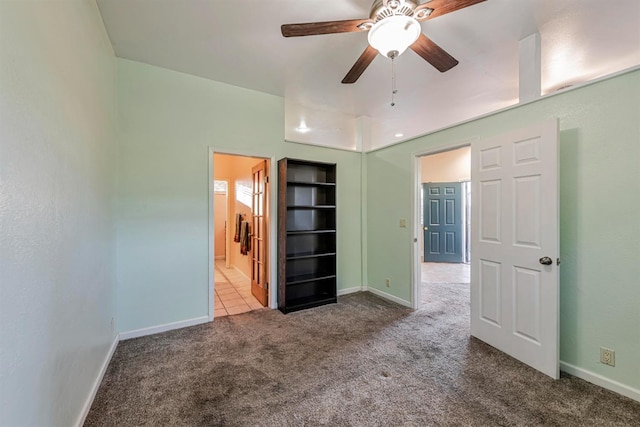 unfurnished bedroom featuring a ceiling fan, carpet flooring, ensuite bath, and baseboards