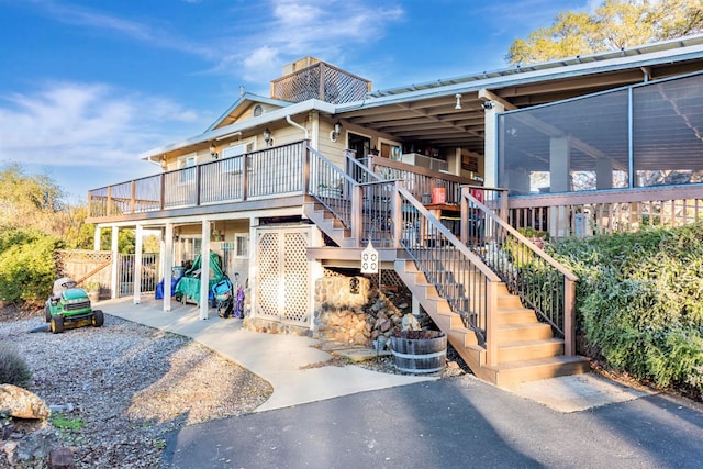 exterior space with stairway, a deck, and a patio