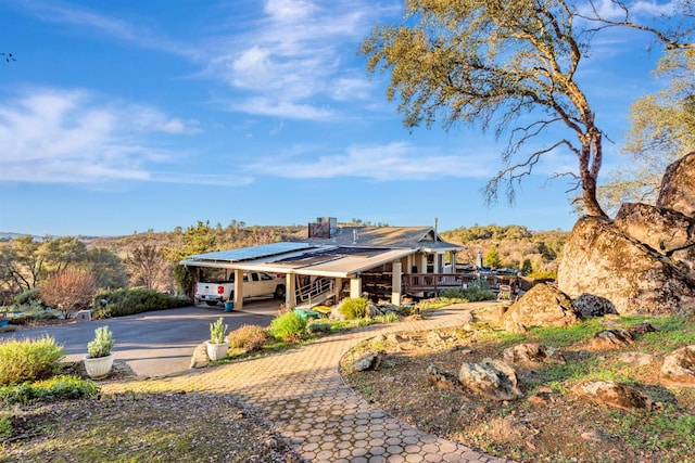 exterior space featuring a carport and decorative driveway