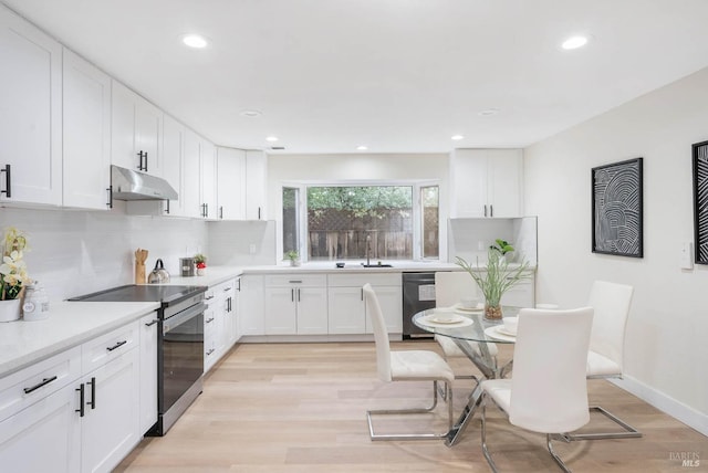 kitchen with electric stove, light hardwood / wood-style floors, white cabinets, black dishwasher, and backsplash