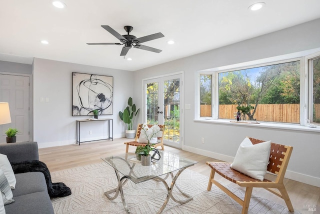 living room with ceiling fan, french doors, and light hardwood / wood-style flooring