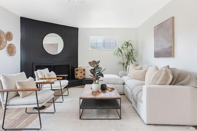 living room with a fireplace and light wood-type flooring