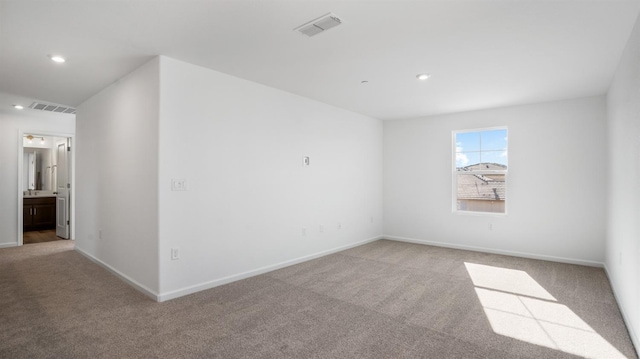 spare room featuring light colored carpet