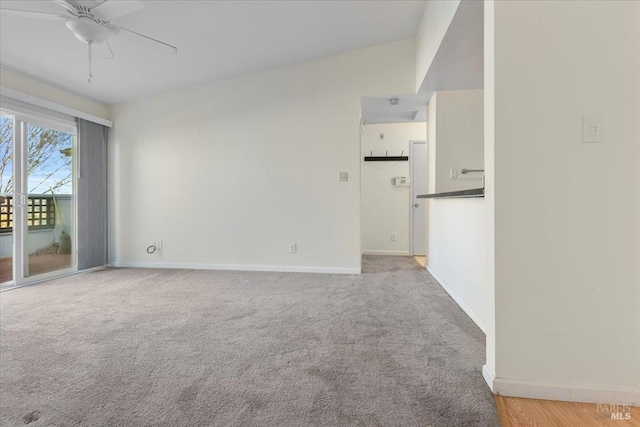 carpeted spare room featuring ceiling fan