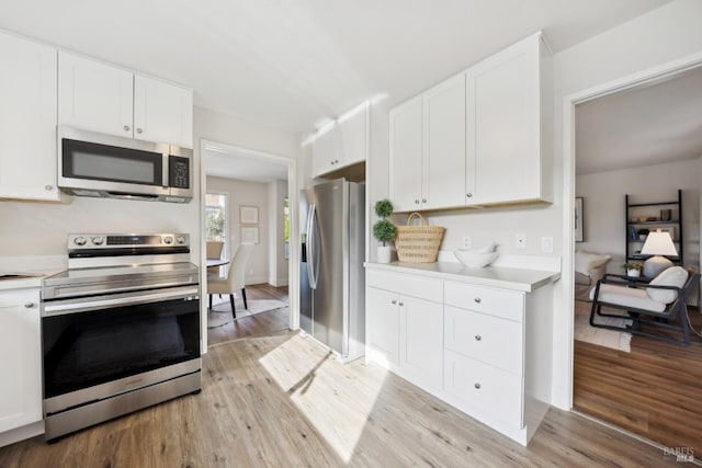 kitchen featuring stainless steel appliances, white cabinetry, and light wood-type flooring