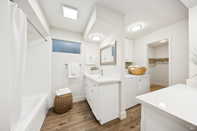 bathroom with shower / bathtub combination with curtain, washing machine and dryer, wood-type flooring, and vanity