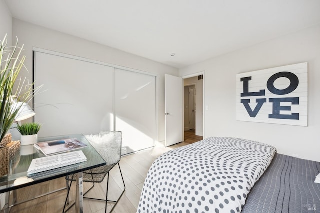 bedroom with light wood-type flooring and a closet