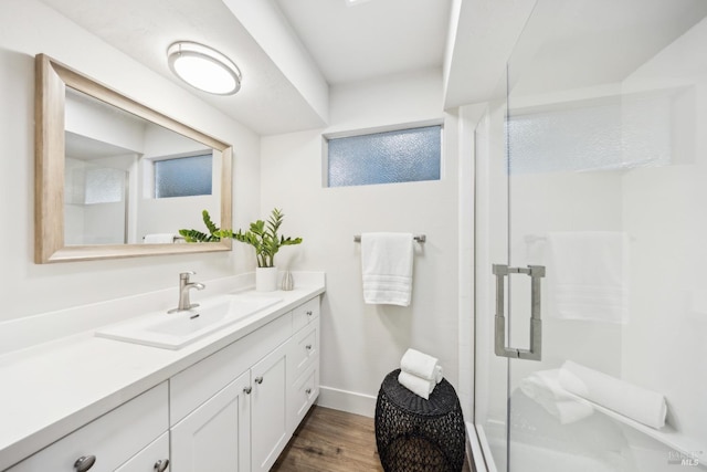 bathroom with an enclosed shower, vanity, and hardwood / wood-style flooring