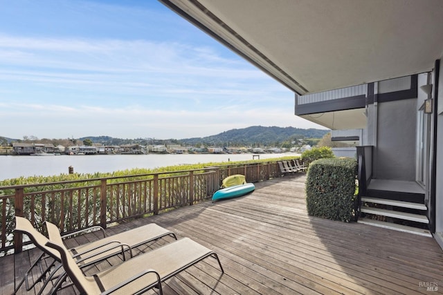 wooden terrace with a water and mountain view