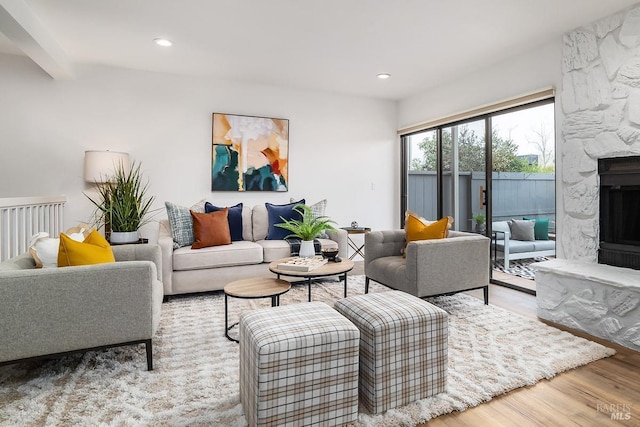 living room with light hardwood / wood-style flooring and a stone fireplace