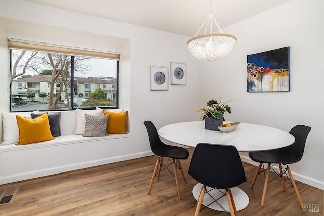 dining area featuring a notable chandelier and wood-type flooring