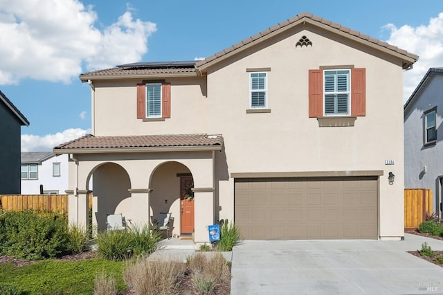 mediterranean / spanish-style home with solar panels and a garage