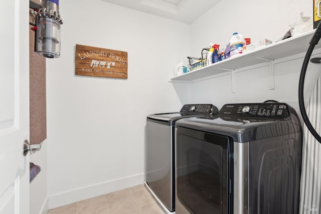 clothes washing area featuring washing machine and clothes dryer and light tile patterned floors