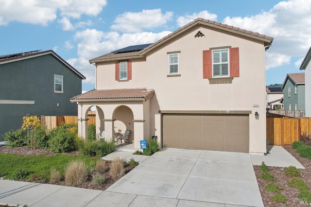 mediterranean / spanish-style home with solar panels and a garage