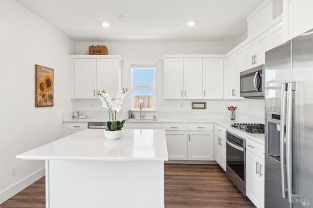 kitchen with sink, white cabinets, appliances with stainless steel finishes, and a center island