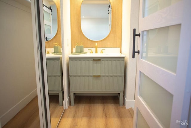 bathroom featuring baseboards, wood finished floors, and vanity