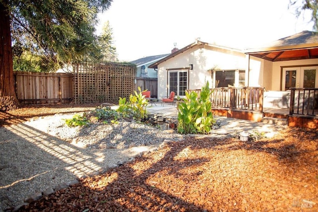 rear view of property with a patio area, a fenced backyard, french doors, and stucco siding