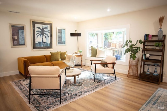 living area featuring baseboards, visible vents, wood finished floors, and recessed lighting