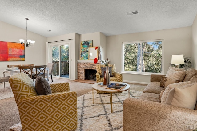 carpeted living room with vaulted ceiling, a textured ceiling, a notable chandelier, and a stone fireplace