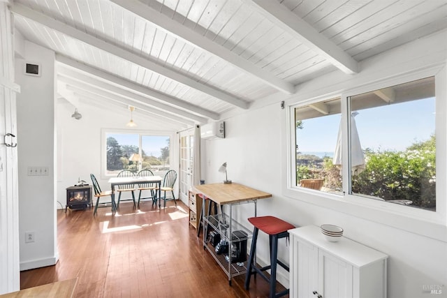 interior space with lofted ceiling with beams and a wall mounted air conditioner