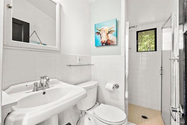 bathroom featuring sink, an enclosed shower, tile walls, and toilet