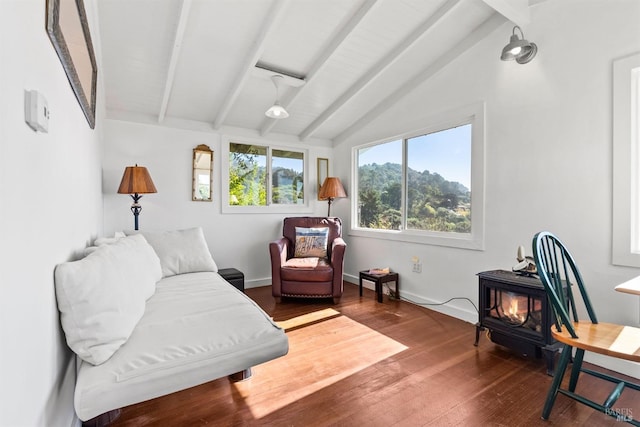 living area featuring lofted ceiling with beams, a wood stove, and hardwood / wood-style floors