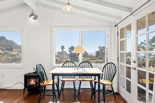 sunroom featuring lofted ceiling with beams and a wood stove