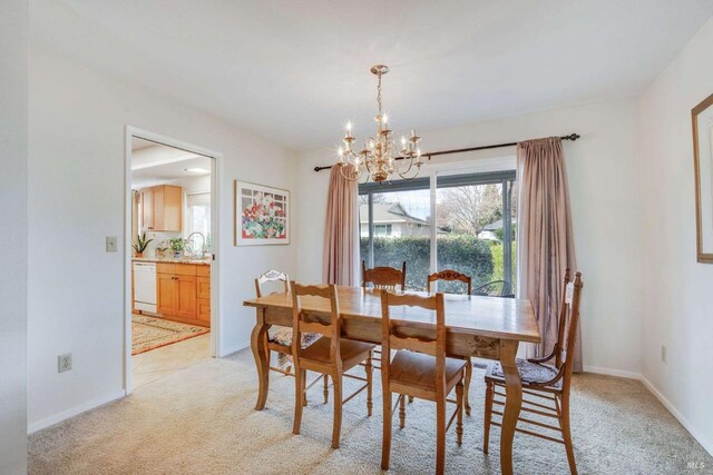 carpeted dining space featuring sink and a chandelier