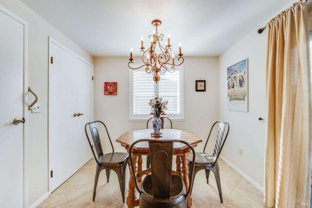 dining area featuring light tile patterned flooring and a chandelier