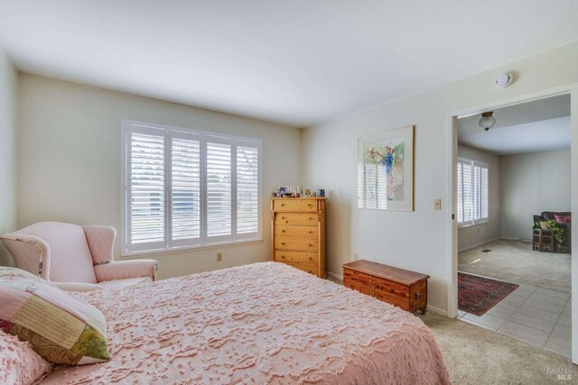 bedroom featuring multiple windows and light colored carpet