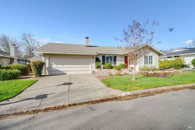 ranch-style house featuring a front yard and a garage