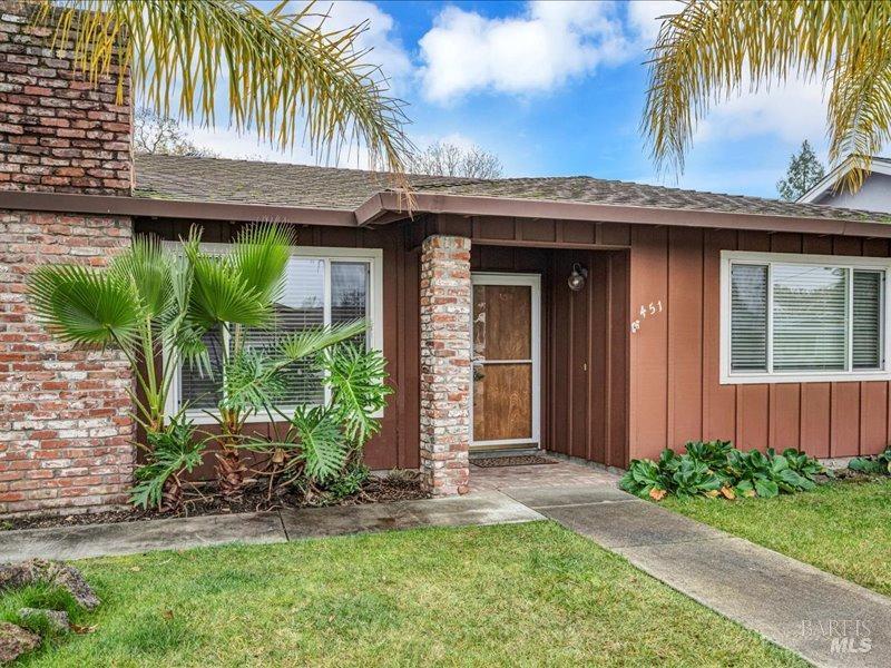 doorway to property with a lawn