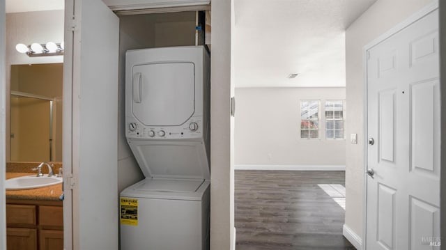 laundry area featuring sink, dark hardwood / wood-style floors, and stacked washer and dryer