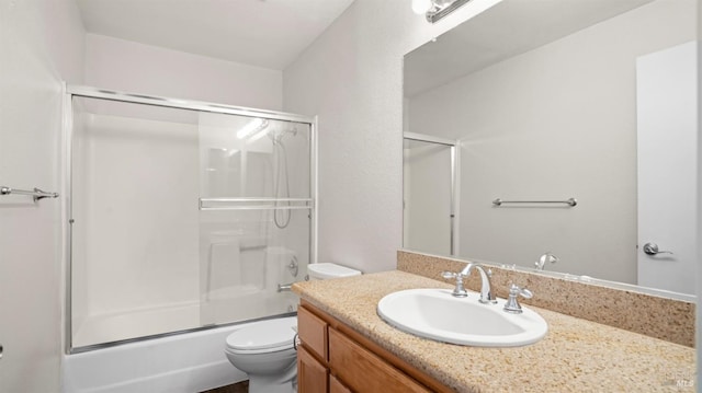 full bathroom with bath / shower combo with glass door, vanity, and toilet