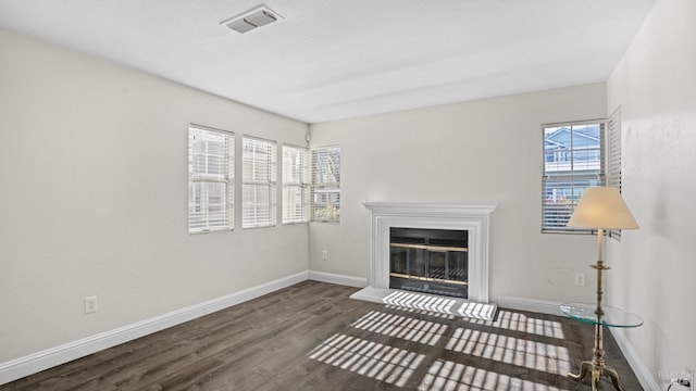 unfurnished living room with dark hardwood / wood-style flooring and a wealth of natural light