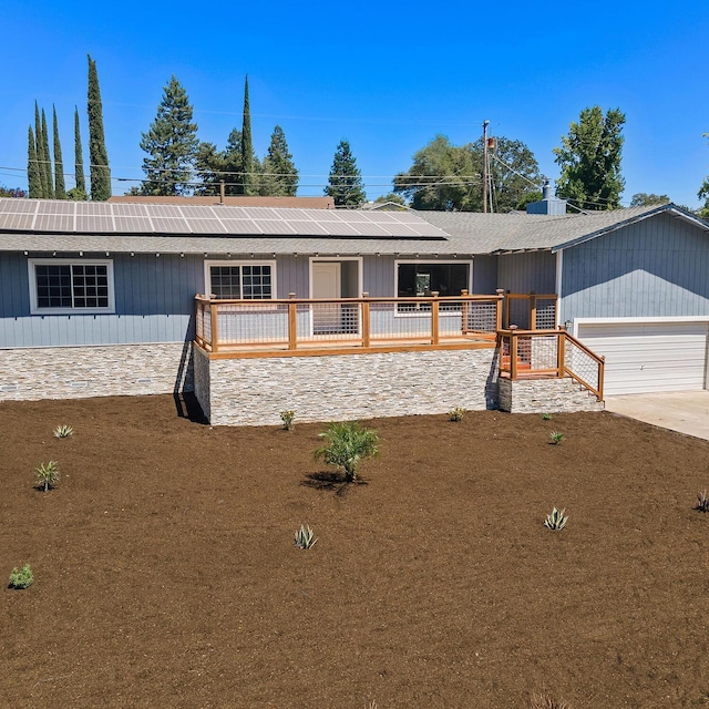 single story home featuring a garage and solar panels