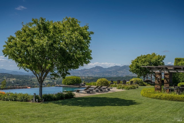 view of home's community featuring a lawn and a water and mountain view