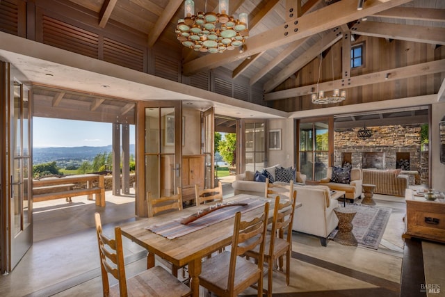 dining area with high vaulted ceiling, concrete flooring, a mountain view, and an inviting chandelier