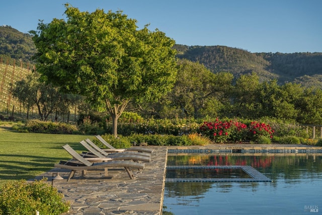 view of property's community with a yard and a water and mountain view