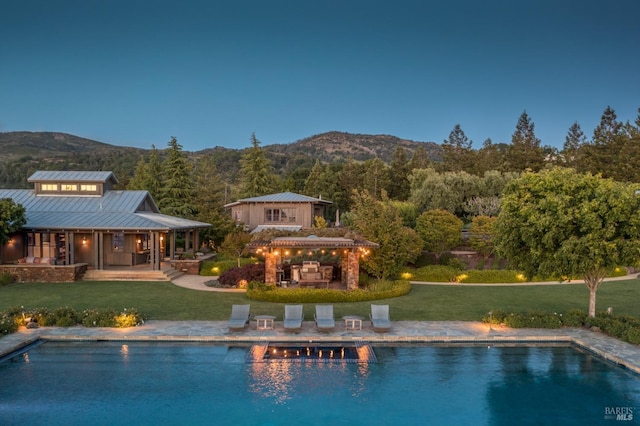 view of swimming pool with a lawn, a patio area, an outbuilding, and a mountain view