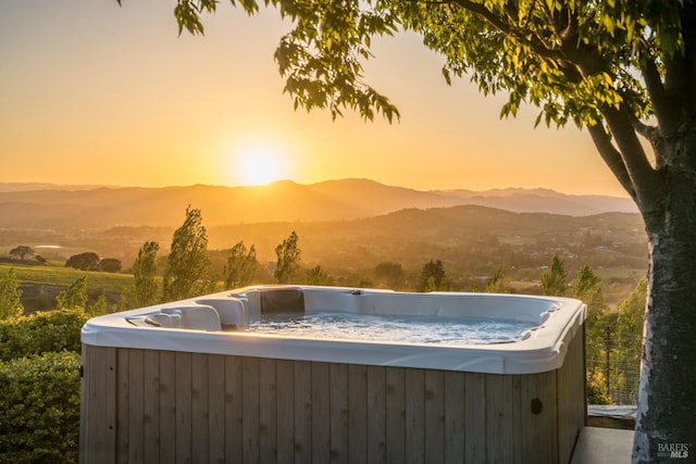 exterior space with a hot tub and a mountain view