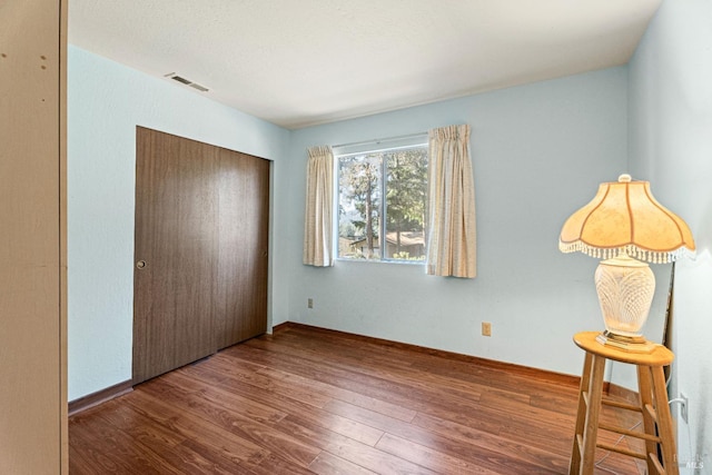 unfurnished bedroom with hardwood / wood-style floors and a closet