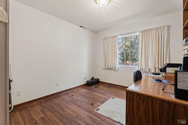 office area with dark hardwood / wood-style floors and a textured ceiling