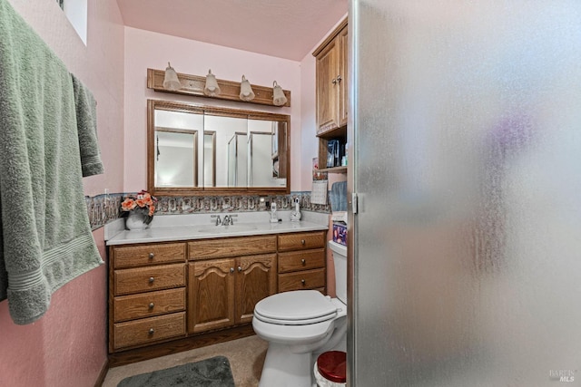 bathroom featuring vanity, toilet, and an enclosed shower