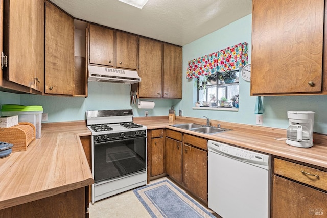 kitchen with butcher block countertops, sink, a textured ceiling, and white appliances