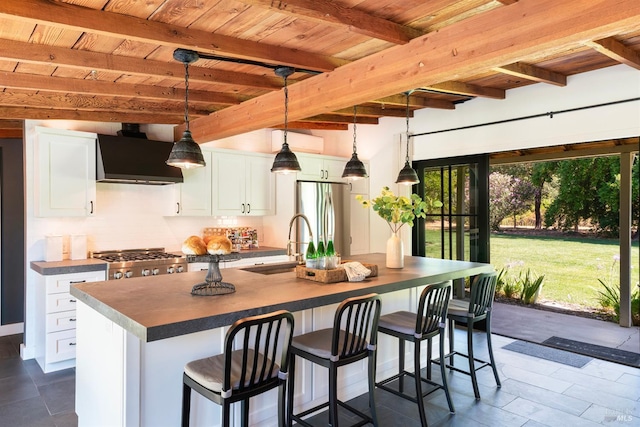 kitchen featuring white cabinets, appliances with stainless steel finishes, pendant lighting, and beam ceiling