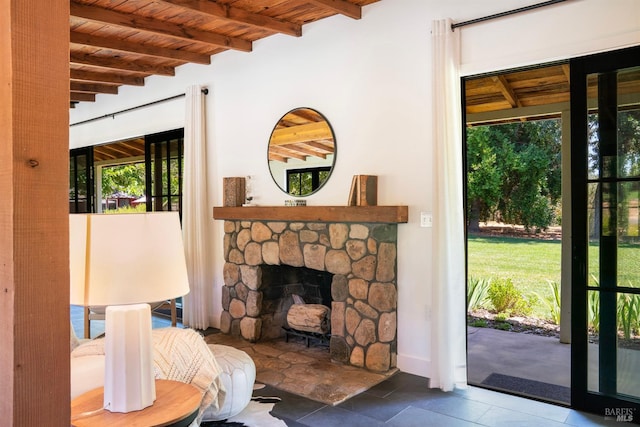 living room with a fireplace, wood ceiling, and beam ceiling