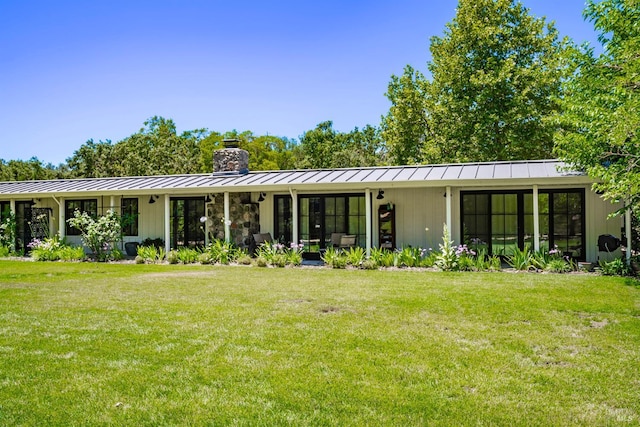 back of house featuring a lawn and a sunroom